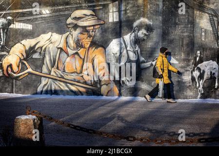 PASSANT DEVANT LES PEINTURES MURALES REPRÉSENTANT LE PASSÉ INDUSTRIEL DE LA VILLE CONNU POUR SES INDUSTRIES DE LA MÉTALLURGIE ET DU TEXTILE, TAMPERE, FINLANDE, EUROPE Banque D'Images