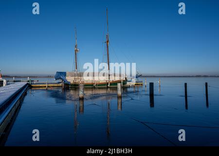 Un voilier dans une marina fermé pour l'hiver.Eau bleue et ciel bleu clair Banque D'Images