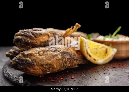 Poisson frit le gobie de la mer Noire, avec du citron et des herbes, sur fond sombre Banque D'Images