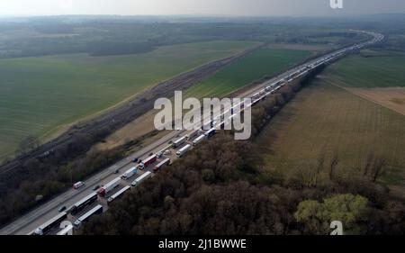 Une vue des camions placés dans la file d'attente de l'opération Brock sur la M20 près d'Ashford dans le Kent alors que les retards de fret se poursuivent au port de Douvres où les services de traversier P&O restent suspendus. Date de la photo: Jeudi 24 mars 2022. Banque D'Images