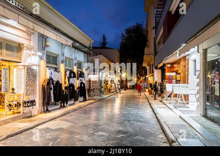 Soirée Blue Hour vue crépusculaire de boutiques et cafés illuminés le long d'une rue étroite dans le quartier central et touristique de Plaka à Athènes, Grèce. Banque D'Images