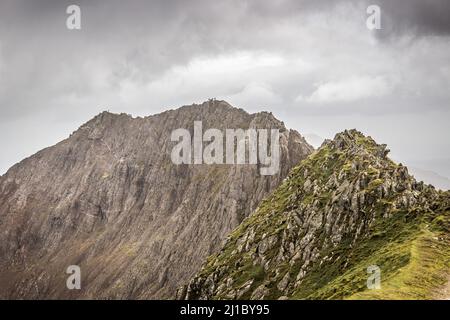 Les marcheurs sont considérés comme de minuscules personnages sur la crête de Crib Goch Banque D'Images