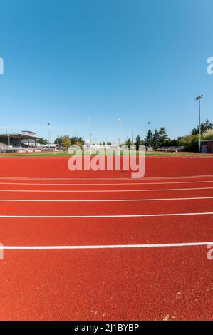 Poteau de football et clôture de but de football sur le circuit et terrain de football de l'école secondaire David Douglas à Portland, Oregon. La piste est au premier plan. Banque D'Images