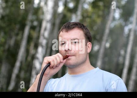 L'homme qui fume un narguilé en plein air en été Banque D'Images