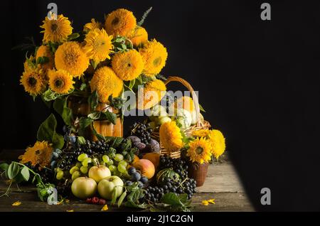 Encore la vie de beaux tournesols décoratifs et des fruits sur un fond noir avec espace de copie avec foyer sélectif avec l'effet du grain de film Banque D'Images