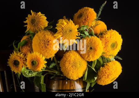 Bouquet de beaux tournesols décoratifs sur fond noir avec un focus sélectif avec l'effet du grain de film Banque D'Images