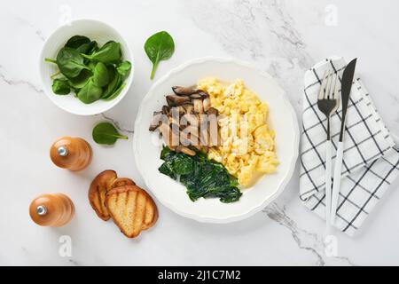 Omelette. Omelette ou frittata aux champignons et au fromage d'huîtres d'épinards sur fond de marbre blanc. Idée petit déjeuner. Vue de dessus avec espace de copie. Banque D'Images