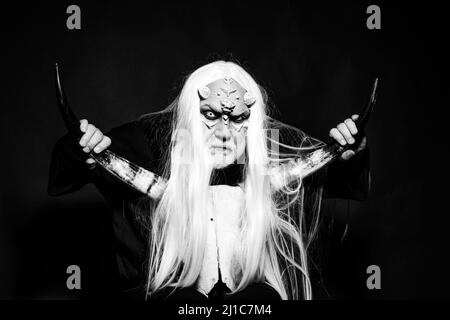 Démon avec des cornes sanglantes sur la tête. Tête de démon isolée sur noir. Homme à tête de taureau. Extraterrestre avec une peau de dragon et une barbe grise. Alchimie ancienne. Viking Banque D'Images