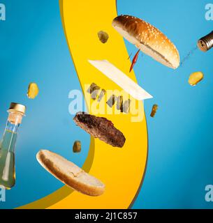 Vue sur un délicieux hamburger avec des ingrédients sur fond bleu et jaune Banque D'Images