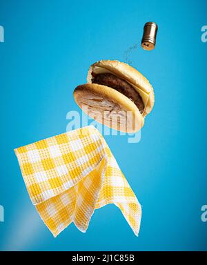Vue sur un délicieux hamburger volant avec serviette en papier bleu Banque D'Images