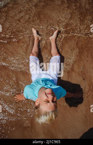 Adolescent sur la vocation estivale à la plage Banque D'Images