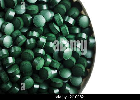 comprimés de spiruline et de chlorella sur fond clair. comprimés verts dans le petit bawl Banque D'Images
