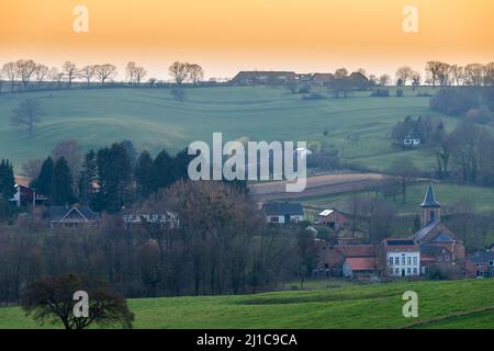Un coucher de soleil au printemps sur het paysage de colline dans le sud des pays-Bas avec une vue sur un petit village, les prairies Banque D'Images