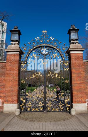 Entrée du parc à Holland Park, Londres, Royaume-Uni, depuis Kensington High Street. Portes ornées de peintures et de lumières dorées sur fond noir Banque D'Images