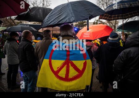 Madrid, Espagne. 24th mars 2022. Un homme est vu porter un drapeau ukrainien avec le symbole de la paix lors d'une manifestation devant l'ambassade russe de Madrid. Des personnes se sont rassemblées pour protester contre l'invasion russe de l'Ukraine portant des tournesols, symbole de l'Ukraine, après un mois de l'invasion. Credit: Marcos del Mazo/Alay Live News Banque D'Images