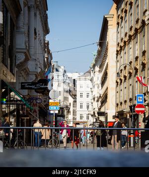 Journée chargée à Vienne. Piétons à pied dans la rue. Panneaux de signalisation et publicités. Belles vieilles maisons. Banque D'Images