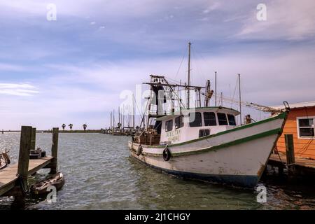 ROCKPORT, TX - 3 FÉVRIER 2020 : bateau à crevettes blanc et vert attaché par corde au quai en bois dans une marina. Banque D'Images