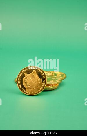 Vue verticale des jetons de crypto-monnaie, tels que dogecoin, bitcoin, litecoin et ethererum avec un arrière-plan vert. Banque D'Images