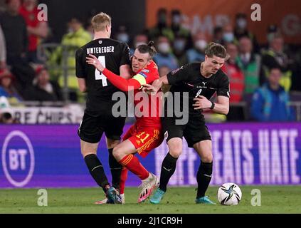 Gareth Bale (au centre), au pays de Galles, combat avec Martin Hinteregger (à gauche) et Marcel Sabitzer, en Autriche, lors du match de demi-finale du qualification de la coupe du monde de la FIFA, au Cardiff City Stadium. Date de la photo: Jeudi 24 mars 2022. Banque D'Images