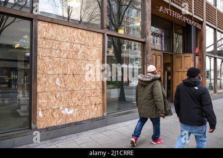 Seattle, États-Unis. 24th mars 2022. Les gens passant une fenêtre de devant écrasée à Anthropologie sur 5th et Pike à Westlake. Après une augmentation du nombre de crimes violents dans le centre-ville d'Amazon a récemment fait la une des journaux en informant les employés travaillant dans le bâtiment Ivy sur 3rd et Pine, ils peuvent choisir un autre lieu de travail jusqu'à ce que la situation s'améliore. La police de Seattle a mis en place un centre de police mobile par le géant de la technologie. James Anderson/Alay Live News Banque D'Images