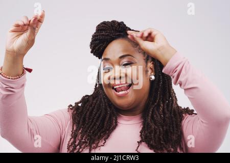 Shes dans la meilleure humeur aujourd'hui. Photo en studio d'une femme d'affaires attrayante se sentant gaie et dansant sur fond gris. Banque D'Images