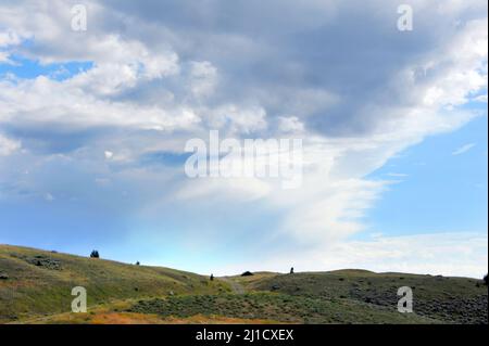 Des nuages orageux se rassemblent sur la colline des monts Absaroka au Montana. Une petite route domine la colline et disparaît dans les nuages. Banque D'Images