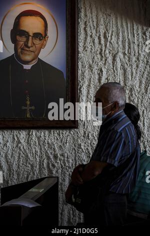 San Salvador, El Salvador. 24th mars 2022. Un homme prie à côté d'une image de Saint Oscar Romero. Le 24th 1980 mars, l'archevêque Oscar Romero a été assassiné par des escadrons de la mort alors qu'il présidait une messe commémorative à la chapelle Divina Providencia. Crédit : SOPA Images Limited/Alamy Live News Banque D'Images