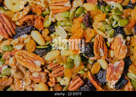 Un cliché plein cadre de fruits secs et de noix se compose de graines de citrouille vertes, d'arachides pelées, de pacanes, de noix, de raisins secs dorés, et des cerises mortes , Banque D'Images