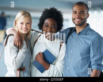 Amis et partenaires d'étude. Un groupe d'étudiants se tenant ensemble et souriant. Banque D'Images