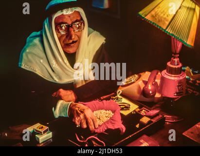 Marchand de perles à son bureau à Sharjah, Émirats arabes Unis, (1984). Avant l'avènement du pétrole, la plongée en perle offrait un moyen de subsistance précaire à de nombreux Arabes du Golfe. Banque D'Images