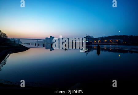 Kiel, Allemagne. 25th mars 2022. Le soleil se lève sur le canal de Kiel derrière le pont haut de Holtenau. Le solde annuel PK Direction générale la Direction générale des voies navigables et de la navigation donne les chiffres du trafic pour l'année 2021 pour le canal de Kiel. Credit: Axel Heimken/dpa/Alay Live News Banque D'Images