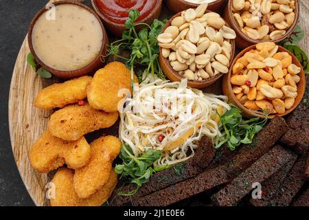 Une variété d'en-cas de bière, arachides, nuggets, sauces de calmar croûtons Banque D'Images