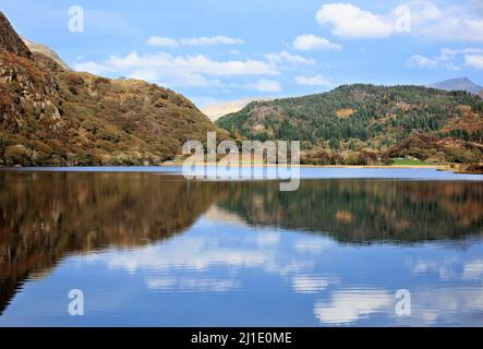 Llyn Dinas forêt au bord de la montagne avec des reflets d'automne sur la surface de l'eau avec des teintes automnales et des teintes de collines boisées à proximité dans la Snowdonia Nati Banque D'Images