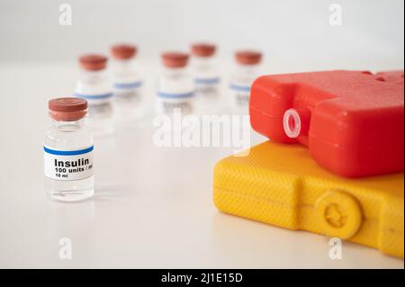 Flacons d'insuline avec des boîtes froides sur fond blanc : refroidissement et stockage corrects de l'insuline. Banque D'Images
