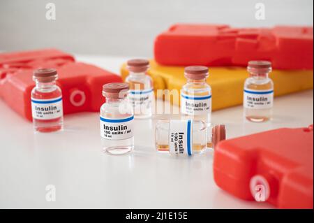 Flacons d'insuline avec des boîtes froides sur fond blanc : refroidissement et stockage corrects de l'insuline. Banque D'Images