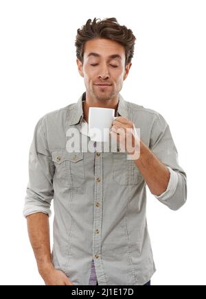 Le café frais dégage une odeur incroyable. Un beau jeune homme qui apprécie l'arôme d'une tasse de café frais. Banque D'Images
