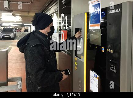 11.01.2022, Allemagne, , Berlin - un homme avec la protection du nez de bouche paie son billet à une machine à billets dans un garage de stationnement. 00S220111D806CAROEX.JPG [MODÈLE Banque D'Images