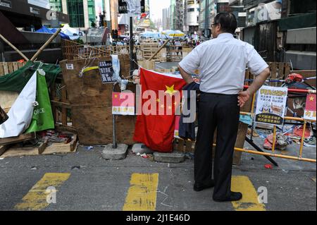 13.10.2014, Volksrepublik Chine, Sonderverwaltungszone, Hong Kong - Un homme se tient devant la barricade de l'un des camps de protestation dans le Mong Kok Banque D'Images