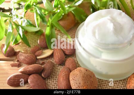 Détail de crème hydratante avec extrait d'amande sur table en bois dans la nature. Vue en hauteur. Composition horizontale. Banque D'Images