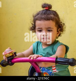 Joli petit garçon Shivaay vélo de conduite à la maison balcon pendant l'été, doux petit garçon photoshoot pendant la lumière du jour, petit garçon profiter du vélo à ho Banque D'Images