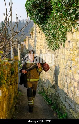 Bradford-on-Avon, Royaume-Uni. 25th mars 2022. James Compton collecte de l'argent pour les organismes de bienfaisance des services d'urgence en portant un mannequin de 70kg sur les collines de Bradford-on-Avon, une jolie mais très vallonnée ville de Wiltshire. Pendant 3 jours, 20 courses par jour, James escaladera l'équivalent de Snowdon. James, qui est pompier sur appel, tente de recueillir des fonds pour 3 œuvres caritatives Blue Light : police Care UK, Fire Fighters Charity et Ambulance Staff Charity. Crédit : JMF News/Alay Live News Banque D'Images