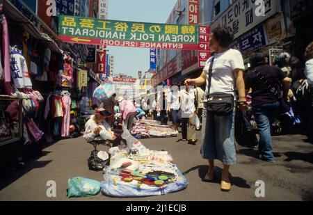 Vendeurs de rue vendant des textiles à une voie de marché dans le quartier commerçant de Dongdaemun à Séoul. Banque D'Images