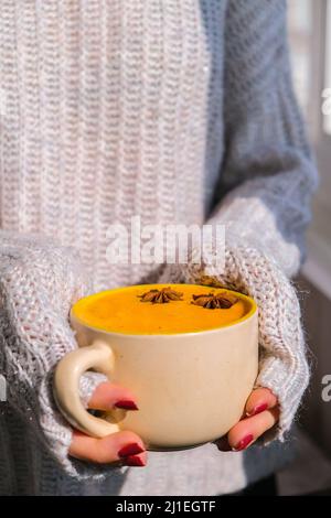 Femme tenant une soupe épicée à la carotte et au gingembre maison. Soupe traditionnelle de citrouille de saison à la texture soyeuse crémeuse. Saine alimentation végétalienne propre. Banque D'Images