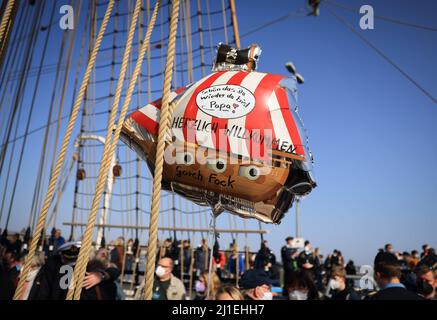 Kiel, Allemagne. 25th mars 2022. « Gent You're back DAD » est écrit sur un ballon en forme de bateau pirate après que le bateau d'entraînement à voile « Gorch Fock » arrime à la base navale de Kiel-Wik. Le navire d'entraînement à la voile de la marine est retourné à son port d'origine après un voyage d'entraînement de quatre mois. Credit: Christian Charisius/dpa/Alay Live News Banque D'Images