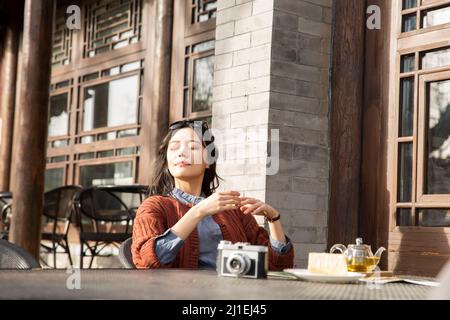 Femelle chinoise de col blanc qui profite de la vie dans un café-terrasse - photo de stock Banque D'Images