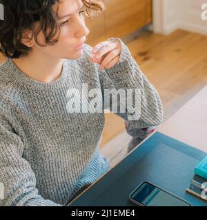 Prélèvement du test de salive pour le coronavirus à la maison. Une adolescente effectue un test rapide de l'échantillon de salive pour détecter la présence du coronavirus Banque D'Images