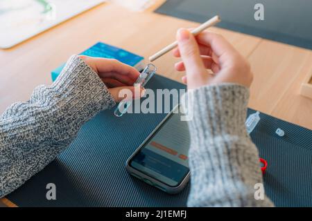 Prélèvement du test de salive pour le coronavirus à la maison. Une adolescente effectue un test rapide de l'échantillon de salive pour détecter la présence du coronavirus Banque D'Images