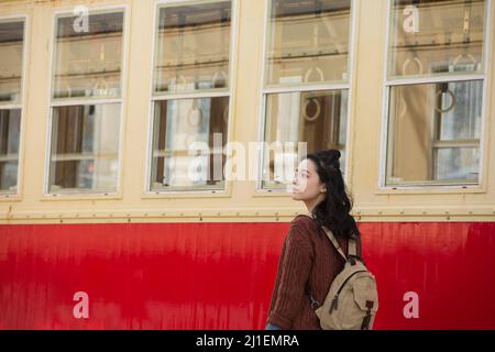 Jeune femme touriste debout à côté d'un vieux tram lent - photo de stock Banque D'Images