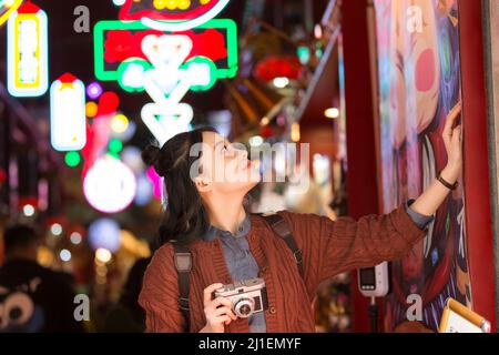 Jeune étudiante d'université admirant l'affiche d'art à un marché de nuit à Beijing - photo de stock Banque D'Images