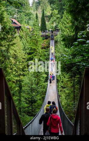 Pont suspendu Capilano lors d'une journée bondée à Vancouver, C.-B., Canada. Pont suspendu entre des arbres verdoyants et de nombreux touristes marchant. Banque D'Images